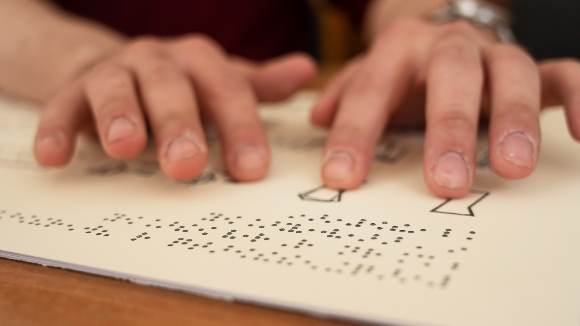 Photo of hands reading in braille