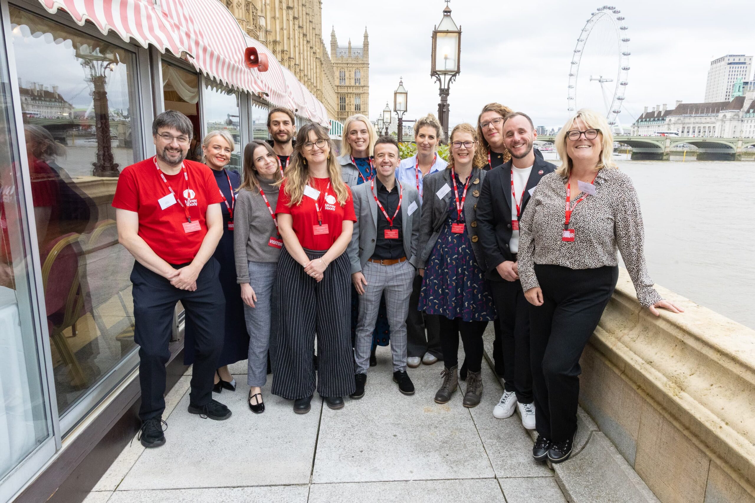 Money Ready colleagues standing at the House Of Lords with the London Eye and River Thames in the background