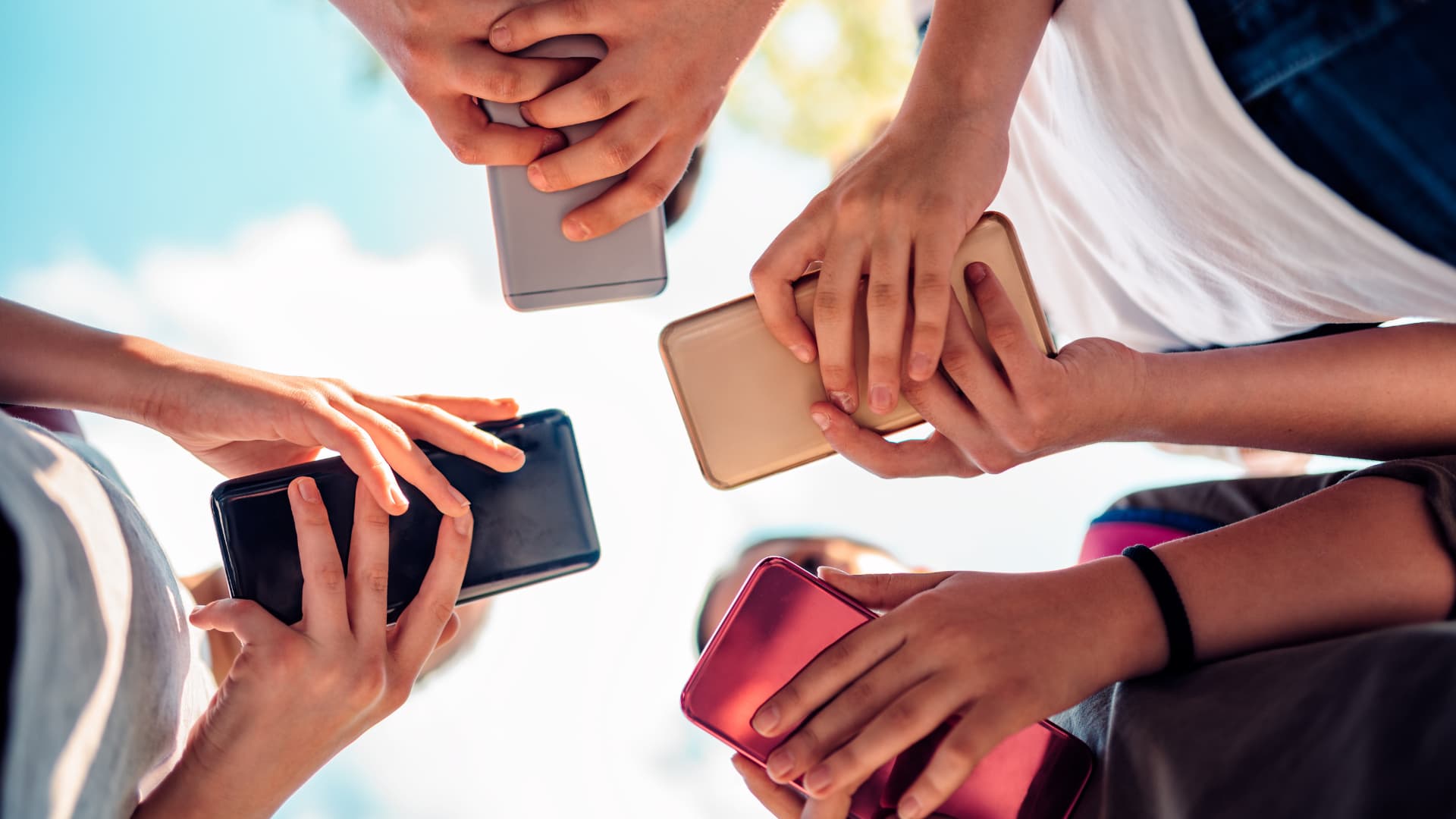 Young people holding mobile phones