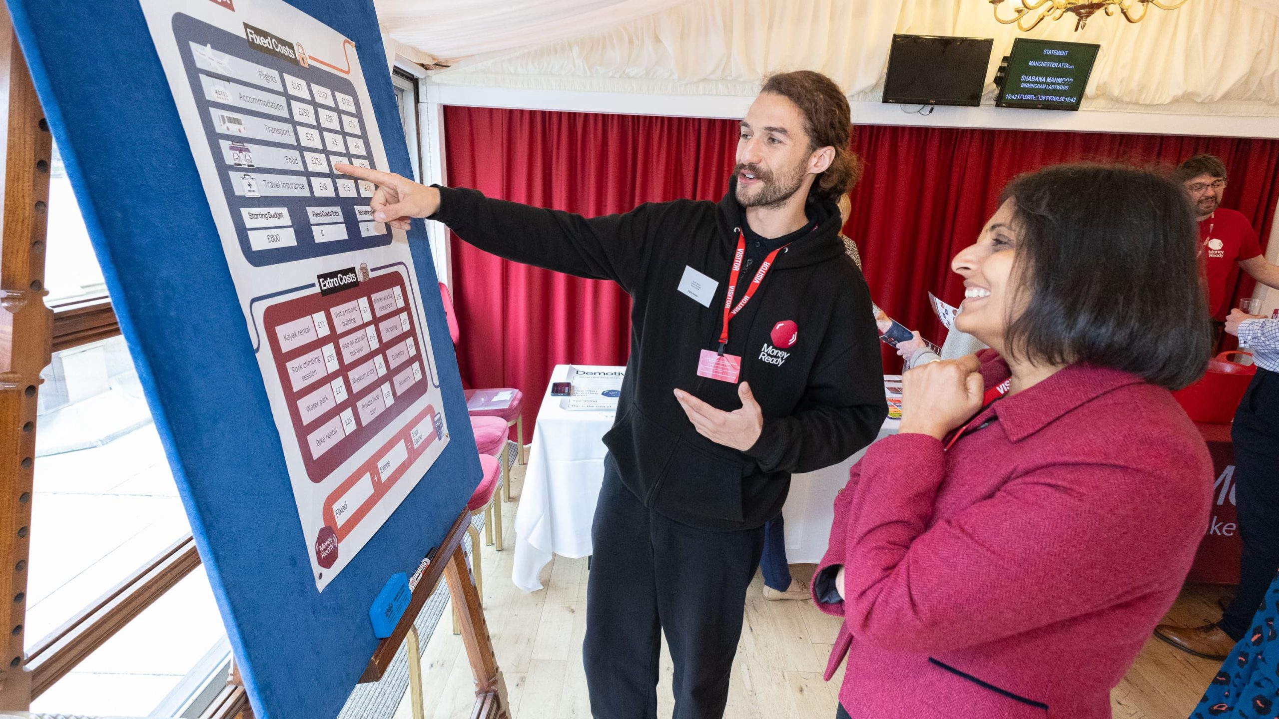 Guest at a Money Ready event looking at a whiteboard with a Money Ready trainer