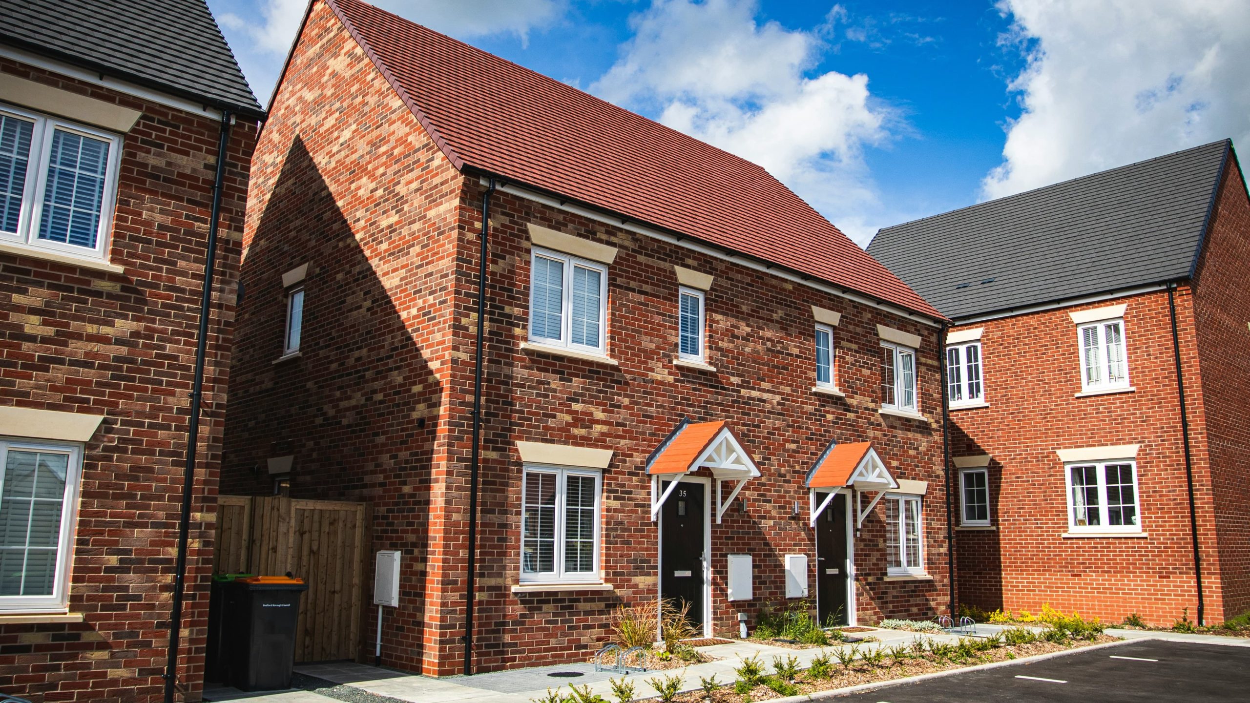 A semi-detached house with red bricks and driveway