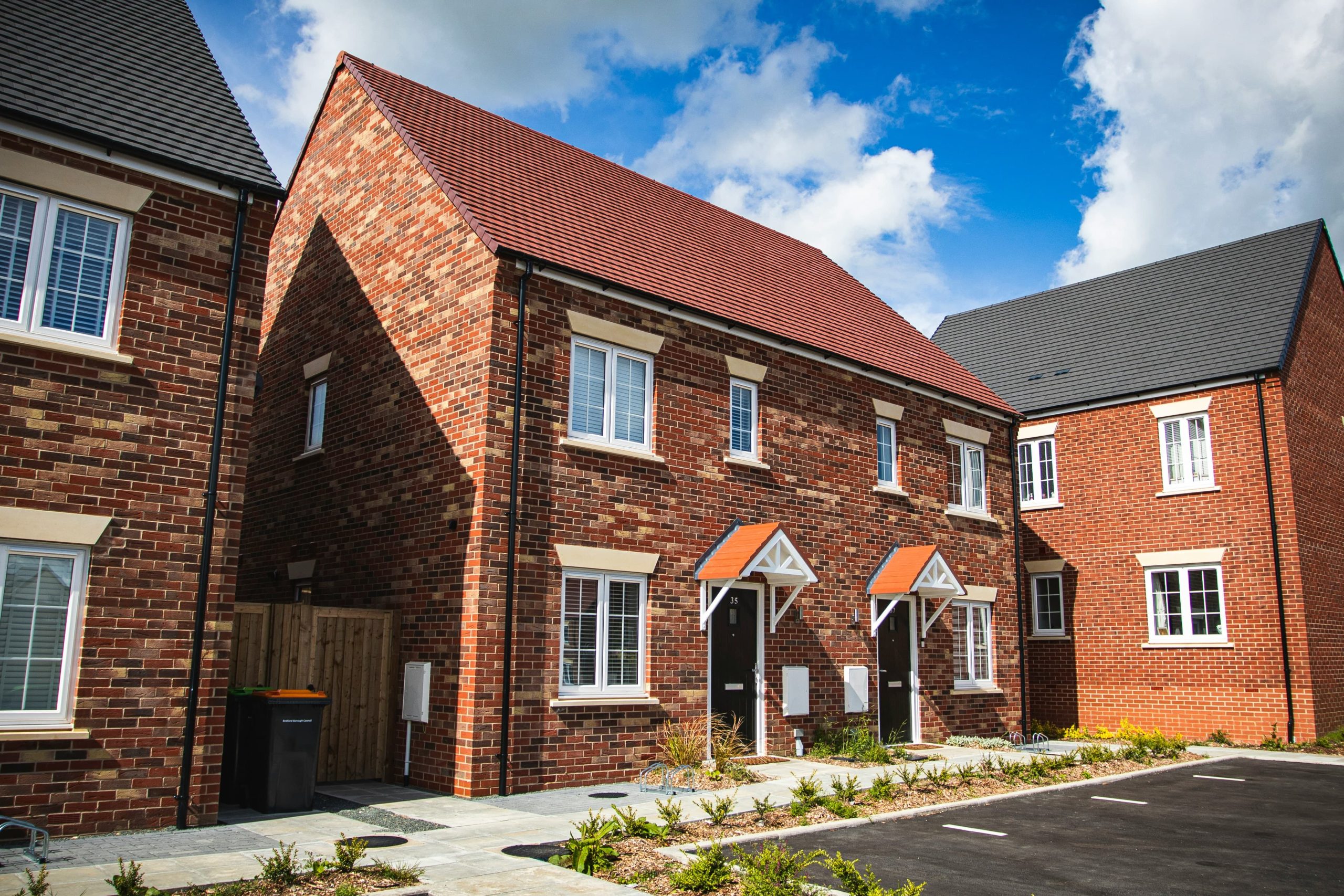 A semi-detached house with red bricks and driveway