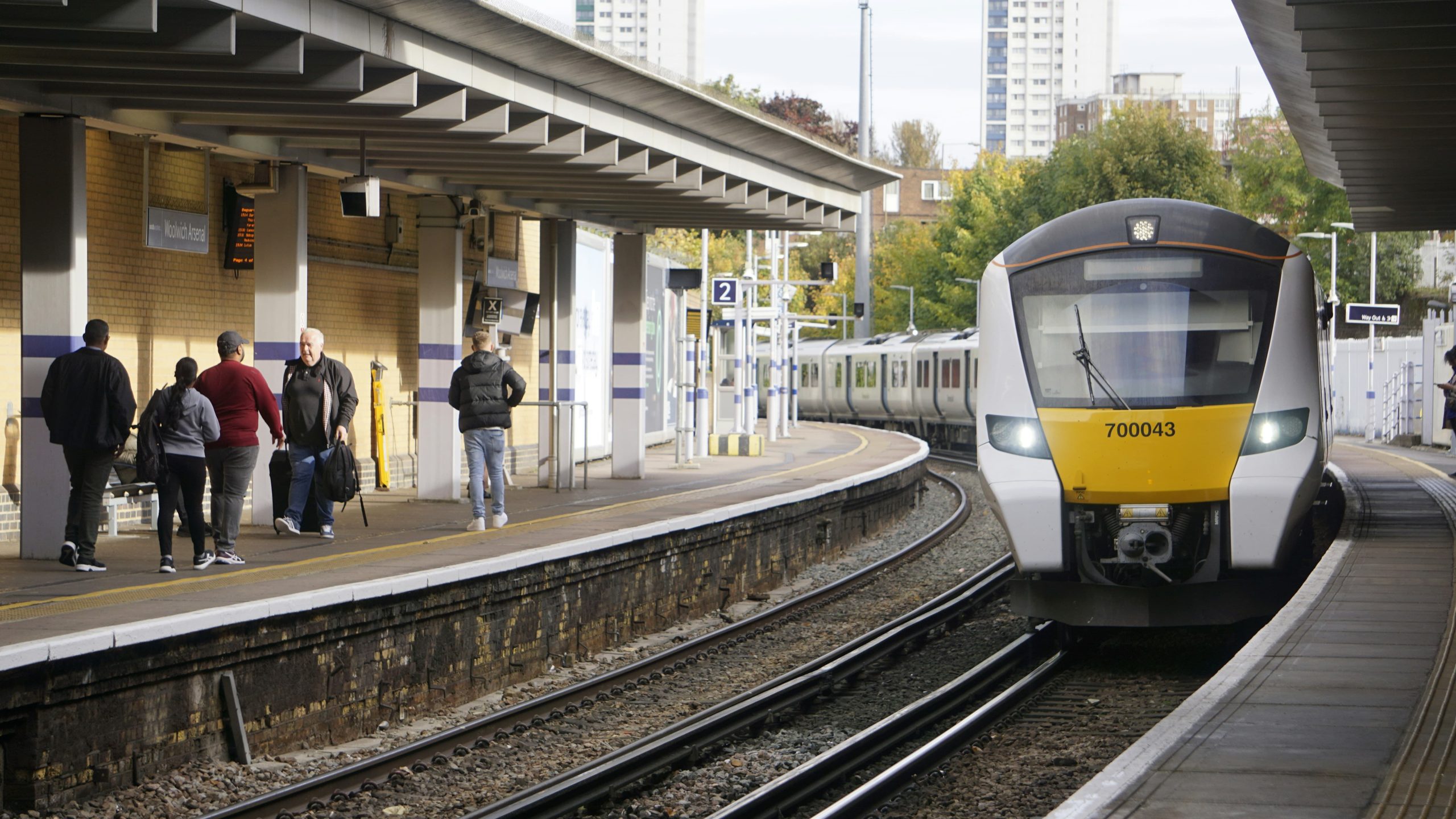 Train station platform with passengers on one side and a train on the other