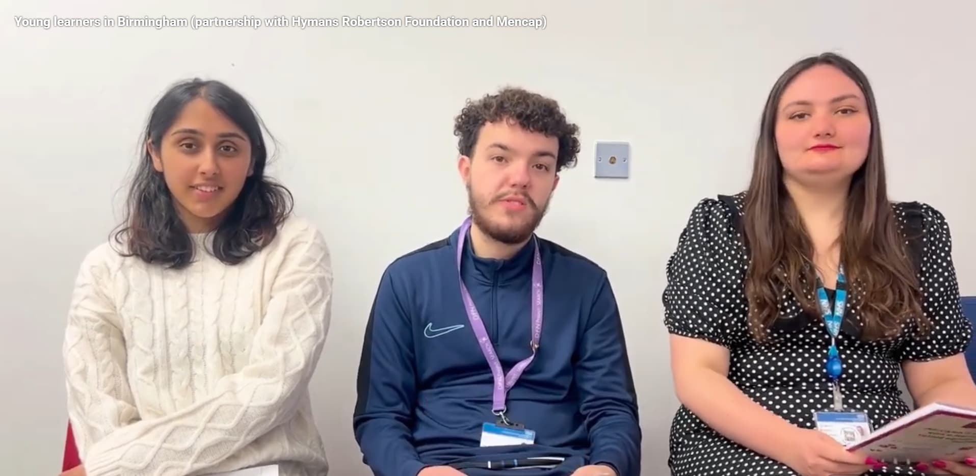 Three young adults sat in a row facing the camera