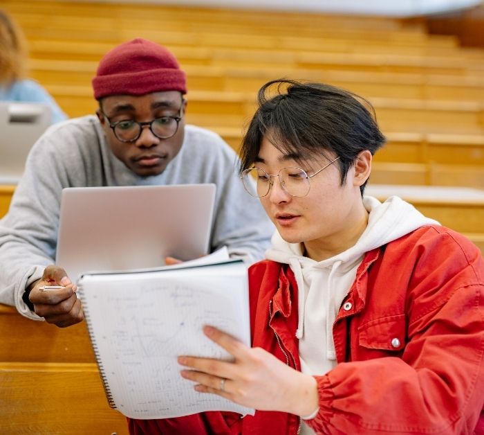 Students talking to each other in a lecture hall.