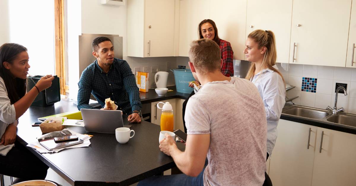 Students talking in a university halls kitchen.