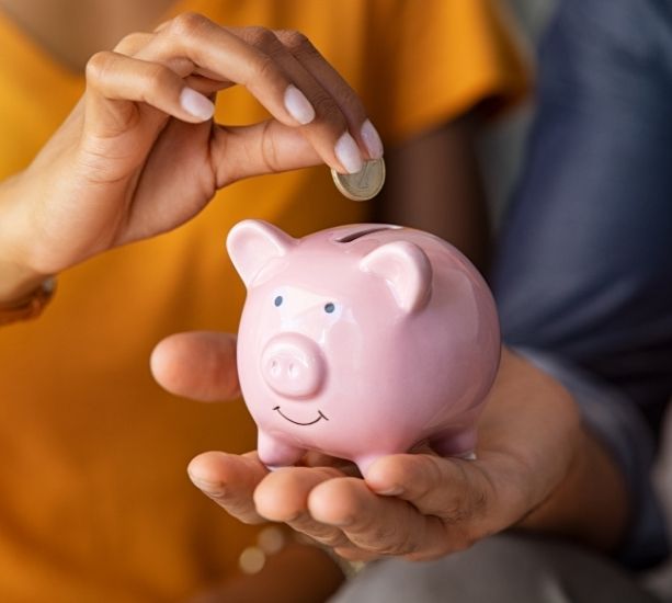 Two people using a piggy bank.